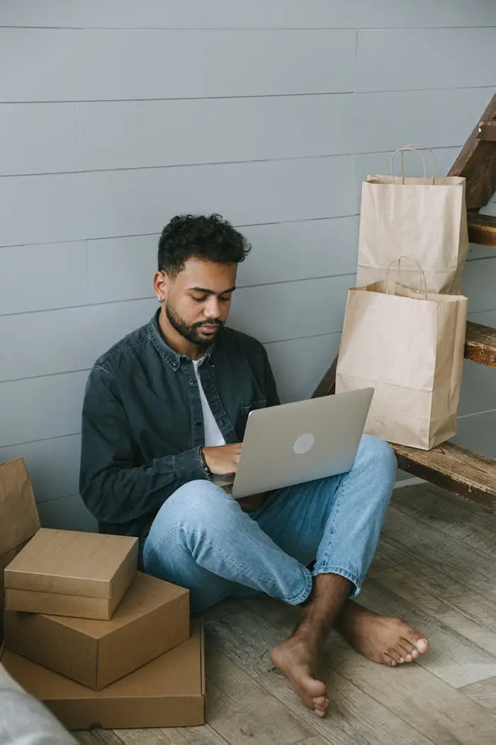 Business owner working on laptop surrounded by packages